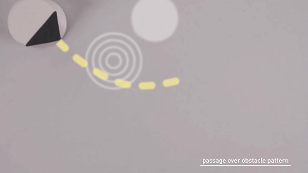 inquadratura dall'alto con un robot che passa sopra un pattern che indica un ostacolo non fisico ma che indica di rallentare la velocità di movimento. La linea di direzione è tratteggiata e piena